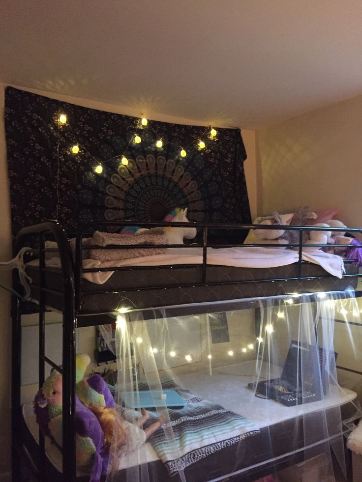 there is a bunk bed with lights on the top and below it in this room