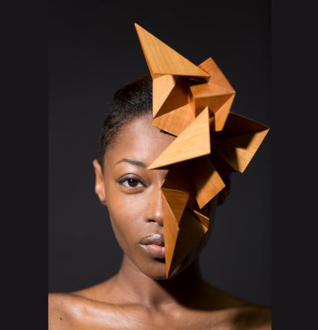 a woman with an origami mask on her face and one half of her head is folded up