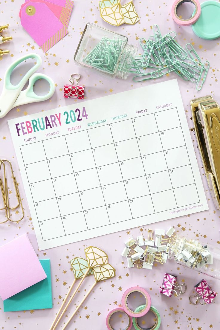 a calendar with scissors, pins and other crafting supplies on top of the table