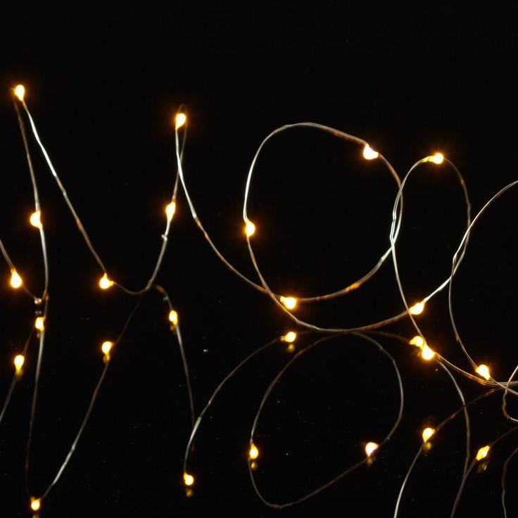 the word love spelled out with lights in the shape of hearts on a black background