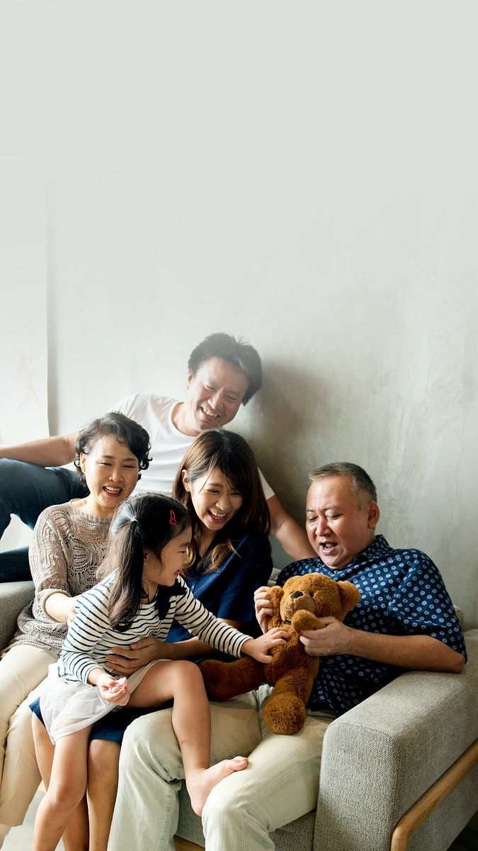 a group of people sitting on top of a couch with a teddy bear in their hands