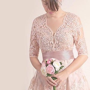 a woman in a pink dress holding a bouquet of flowers with her hands on her hips