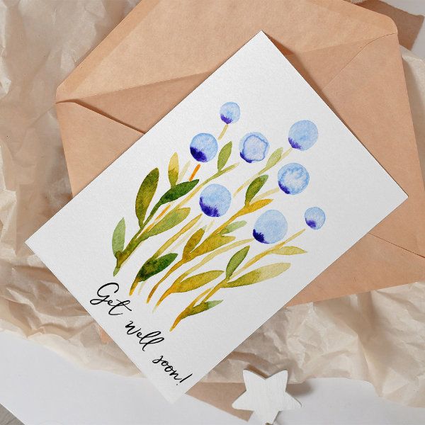 a card with watercolor flowers on it sitting next to an envelope that says congratulations