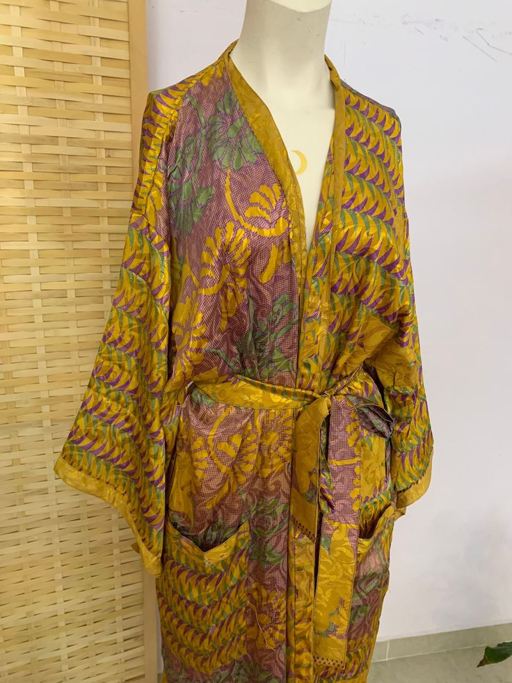 **this is a ONE of a kind vintage eco silk kimono only one in all the world  just like you :) ✨ this luxury's fabric had gone a long journey,  hand picked from special places  to bring you the most silky Beautiful ones we could find in order to recycle and create this unique goddess kimono  *you may find some imperfections in fabric,  this should be loved as a reminder of this fabrics journey  ⚛️ it's a one loss free size. so it's also great as a gift 🎁  can also be Warren as a wrap dress  has Vintage Long Kimono For Vacation, Yellow Bohemian Kimono With Kimono Sleeves, Hippie Festival Robe With Kimono Sleeves, Vintage Silk Kimono For Summer, Summer Vintage Silk Kimono, Bohemian Yellow Kimono For Festivals, Yellow Bohemian Kimono For Festival, Long Yellow Kimono For Festivals, Long Vintage Kimono For Festivals