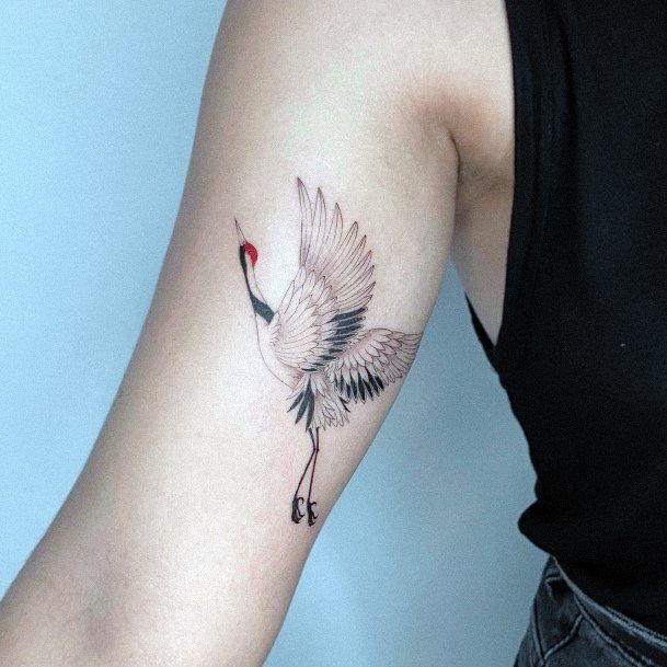 a woman's arm with a bird tattoo on it