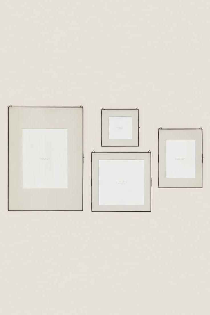 three white square frames on a wall with one empty and the other half missing, all in different sizes