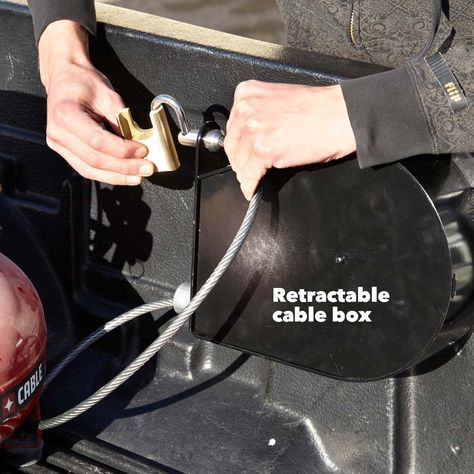 a person holding onto a table box attached to a vehicle's side door with the words retractable cable box on it