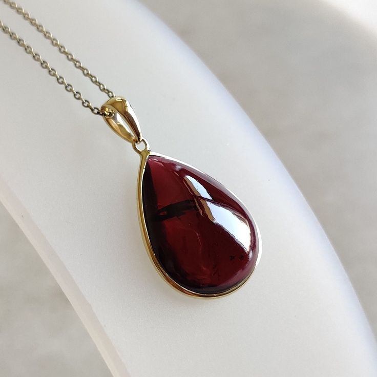 ITEM DESCRIPTION: >> The Pendant is made from Solid 14K Yellow Gold. Gemstone used is absolutely natural and ethically sourced. >> Natural Garnet in cabochon cut and pear shape with bezel setting is studded on it with utmost precision.  >> This is a minimalist design and is absolutely hassle-free and everyday jewelry.  Gem: Garnet Gem size: 15x20 mm pear Gem weight: 15.54 carats Gold purity: 14K (58.33% approx.) Gold weight: 0.57 grams  Gross weight: 3.68 grams The Gold purity is guaranteed and it comes with authentic 14K gold hallmark. Since this Pendant are handmade, It is Nickel/Lead FREE.  CUSTOMIZATION: --> You can choose your own gemstone. --> Kindly drop a message for the same. CUSTOMER SUPPORT: --> We are available 24/7 to respond to all your queries!  PACKAGING: --> The pendant co Yellow Gold Pear-shaped Necklace For Gift, Fine Jewelry Gemstone Pendant For Gift, 14k Gold Pendant Gemstone For Gift, Pear-shaped Yellow Gold Gemstones For Gifts, Cabochon Drop Jewelry For Gifts, Classic Polished Gemstones As A Gift, Fine Garnet Necklace As Gift, Fine Jewelry Garnet Necklace As Gift, Fine Garnet Necklace For Gift