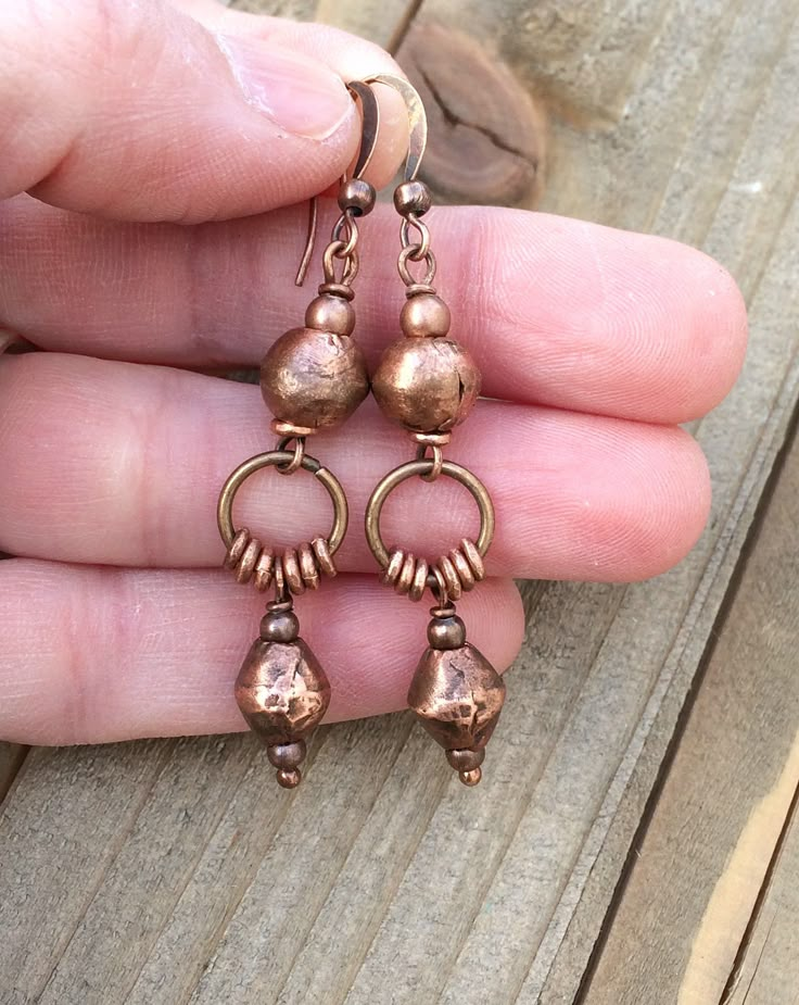 Bohemian style copper dangle earrings with Ethiopian copper. Rustic, handcrafted, fair-trade Ethiopian copper beads make these gorgeous earrings truly unique. Light-weight and versatile, copper pairs perfectly with other metal accessories and compliments a variety of wardrobe styles. A great everyday pair of earrings that enhance your favorite outfit. Product overview: * Made with handcrafted Ethiopian copper and copper plated ear wires * Light-weight and versatile, looks great copper or other m Bronze Earthy Dangle Earrings, Nickel-free Rustic Copper Earrings, Bohemian Brown Electroformed Earrings, Rustic Adjustable Copper Earrings, Vintage Hand Forged Copper Earrings, Rust Colored Bohemian Metal Jewelry, Bohemian Rust-colored Metal Jewelry, Brown Hammered Copper Earrings, Rustic Brass Dangle Earrings