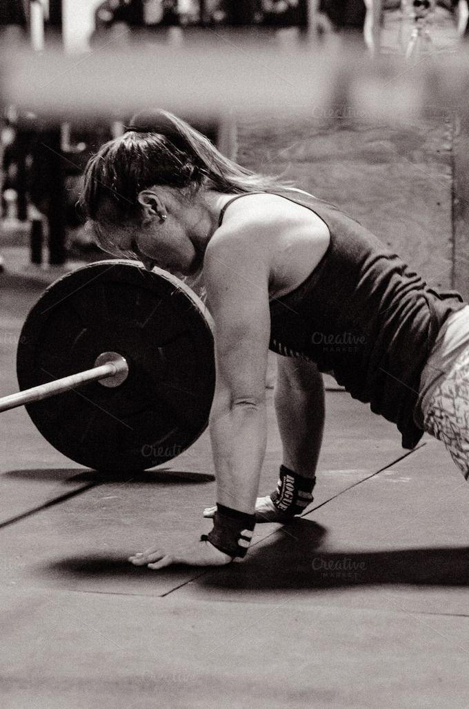 a woman lifting a barbell with one hand