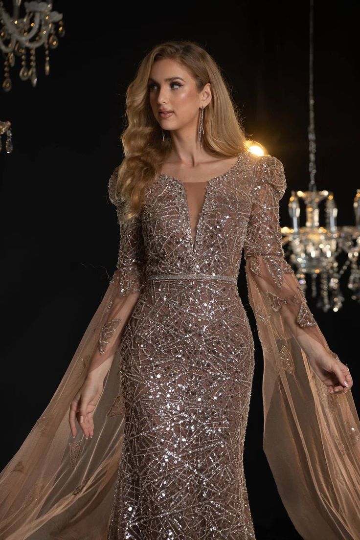 Elevate your evening with this elegant light purple sequin evening gown. The intricate sequin embellishments add a dazzling sparkle, making you the center of attention at any event. Featuring flowing cape sleeves, this gown exudes drama and sophistication, perfect for making a grand entrance. The fitted silhouette high Luxury Sequin Evening Dress For Party Season, Luxury Evening Gown With Sequins, Luxury Sequined Evening Gown, Glamorous Sequined Floor-length Evening Dress, Glamorous Sequined Evening Dress, Luxury Sequin Dress For Prom Season, Glamorous Sparkling Sequin Fabric For Gala, Sparkling Sequin Evening Dress, Glamorous Mother Of The Bride Dress For Gala