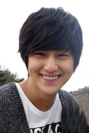 a young man with black hair smiling at the camera