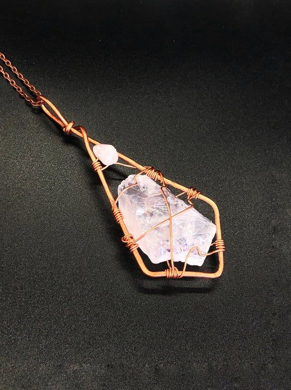 This is a stunning light pink colored pendant. It is made of a tumbled raw stone of rose quartz and rose quartz bead in Scythian tribal style. The stone length is around 2.5 inch, after wrapping it's about 4.5 inches with bail. I've wrapped it in copper wire in unique pattern. It comes with a copper chain 23 inches long.Rose Quartz purifies and opens the heart at all levels to promote love, self-love, friendship, deep inner healing and feelings of peace. Calming and reassuring, it helps to comfo Rose Gold Rose Quartz Jewelry For Meditation, Healing Rose Quartz Gemstone Necklace, Spiritual Rose Quartz Gemstone Necklaces, Rose Quartz Gemstone Necklaces For Meditation, Rose Quartz Gemstone Necklace For Meditation, Handmade Rose Quartz Jewelry For Meditation, Rose Gold Crystal Necklaces With Rose Quartz Gemstone, Wire Wrapped Rose Quartz Pendant Necklace, Rose Quartz Pendant Necklaces For Healing