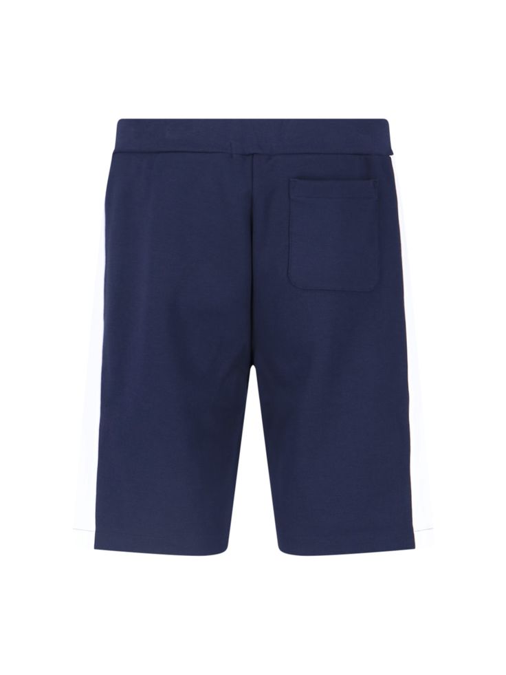 Polo Ralph Lauren logo sporty shorts in a blue cotton blend, with white side band detailing, an elastic waistband, a drawstring closure, two side pockets, tone-on-tone embroidered logo at the front, a back welt pocket, and white logo embroidery at the front. Casual Blue Bottoms With Logo Waistband, Casual Athletic Shorts With Side Stripes For Summer, Casual Summer Athletic Shorts With Side Stripes, Casual Sports Shorts With Side Stripes, Streetwear Shorts With Logo Waistband, Casual Athletic Shorts With Side Stripes, Athleisure Bottoms With Side Stripes, Blue Sporty Bottoms With Contrast Stripes, Sporty Blue Bottoms With Contrast Stripes