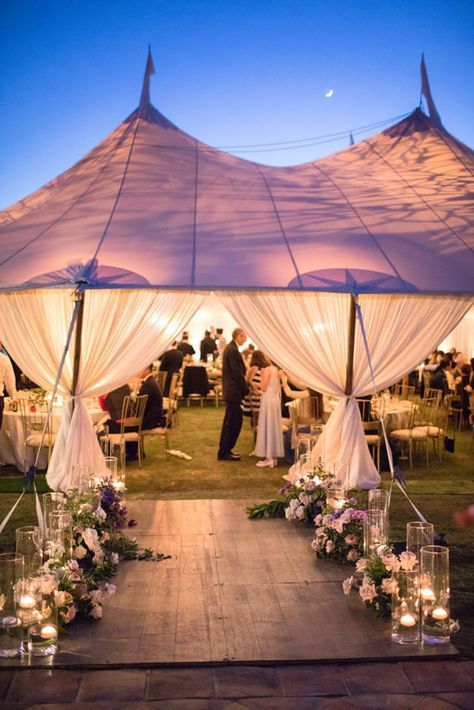 an outdoor wedding with white drapes and candles