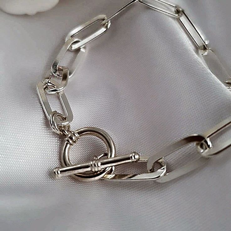 PRODUCT DESCRIPTION This beautiful sterling silver paperclip bracelet is a necessary accessory in your daily combination. This bracelet is elegant, chic, and resistant as it's high-quality solid sterling silver with a toggle clasp which creates the perfect look! MATERIAL ✦Solid high-quality 925 Sterling Silver. MEASUREMENT AND SIZE (in the picture) ✦The total length of each bracelet is 6 inches (15cm). choose length from the drop-down menu. ✦ Each Link Size is 6mm in width * 16mm in length. ✦ Th Traditional Sterling Silver Chain Bracelet, Luxury Link Bracelets With Sterling Silver Clasp, Luxury Adjustable Sterling Silver Link Bracelet, Trendy Sterling Silver Chain Bracelet With Lobster Clasp, Elegant Silver Paperclip Chain Bracelet, Elegant Silver Charm Bracelet With Paperclip Chain, Modern Silver Sterling Silver Paperclip Bracelet, Silver Metal Paperclip Bracelet For Everyday Wear, Silver Metal Link Paperclip Bracelet