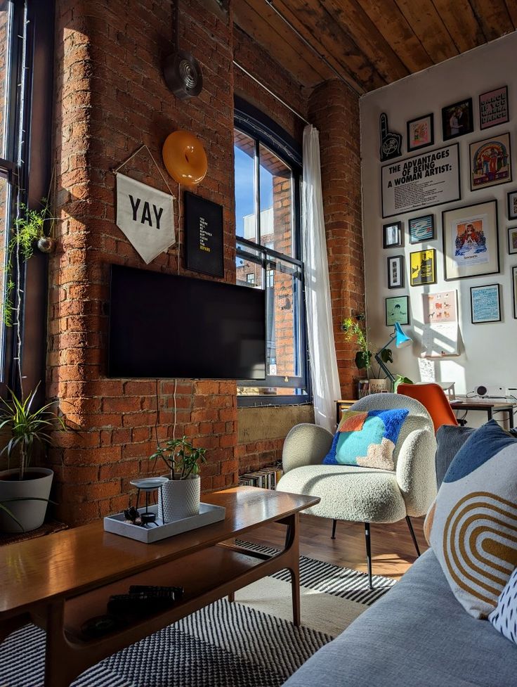 a living room filled with furniture and a flat screen tv mounted on the wall above a wooden coffee table