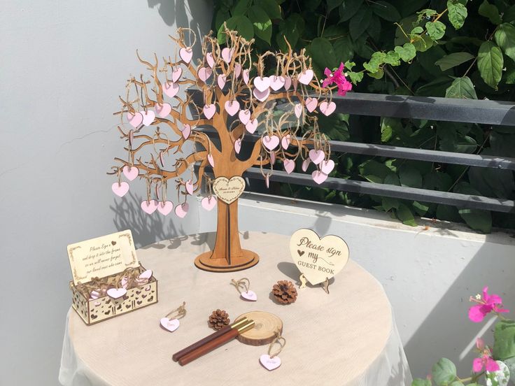 a table topped with a heart shaped tree next to other items on top of it