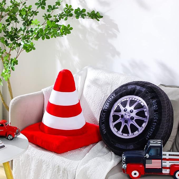 a red and white fire truck sitting on top of a couch next to a green tree