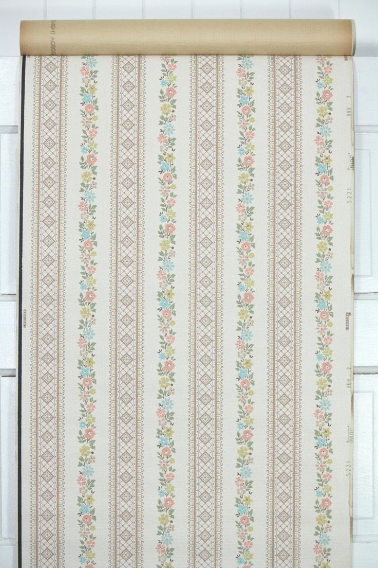 a white and blue striped curtain with flowers on it