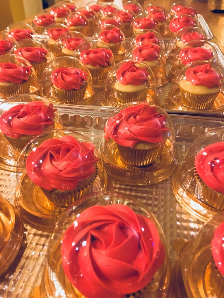 cupcakes with red frosting are on display