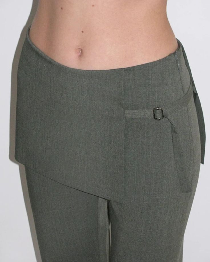 Archive Pants in Dark GreyPaloma Wool women's mid-rise skirt pants in brown. These pants feature an attached mini-skirt that overlaps the straight leg bottoms underneath.FEATURES Side concealed zip closure Overlapping skirt with tie closure Straight leg Mid-rise Materials: 53% recycled polyester, 43% mulesing free wool, 4% elastane Made in Spain Pants With Attached Skirt, Womens Bottoms Pants, Paloma Wool Pants, Pants With Buttons On Side, Pant Skirt Outfit, Skirt Pants Outfit, Skirt Over Pants Outfits, Skirt Over Trousers, Skirts Over Pants