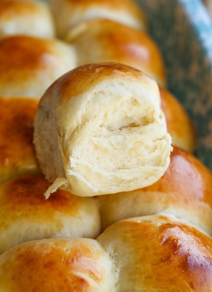 rolls are stacked on top of each other in a blue bowl