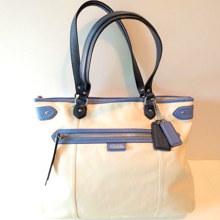 Coach Daisy Spectator Emma Genuine Leather Cream, Navy And Medium Blue Tote With Double Handles And Zip Closure. Cream Satin Dust Cover Included! Details: Smooth Genuine Leather Cream Body Navy And Medium Blue Trim Zip-Top Closure Front: Zip Pocket Back: Open Pocket Inside: Navy Satin Lining / 1 Zip And 2 Multifunction Pockets Approx. Dimensions: 16" (W) X 12.5" (H) X 4" (D) Handle Drop 8.5" Excellent Condition, Never Worn Nwot Smoke-Fee Home Same Or Next Day Shipping Office Bags In Cream With Zipper Closure, Cream Office Bag With Zipper Closure, Cream Office Bags With Zipper Closure, Cream Coach Bags For Office, Office Shoulder Bag With Cream Leather Handles, Cream Shoulder Bag With Leather Handles For Office, Classic Cream Shoulder Bag, Coach Beige Office Bags, Beige Coach Satchel For Everyday