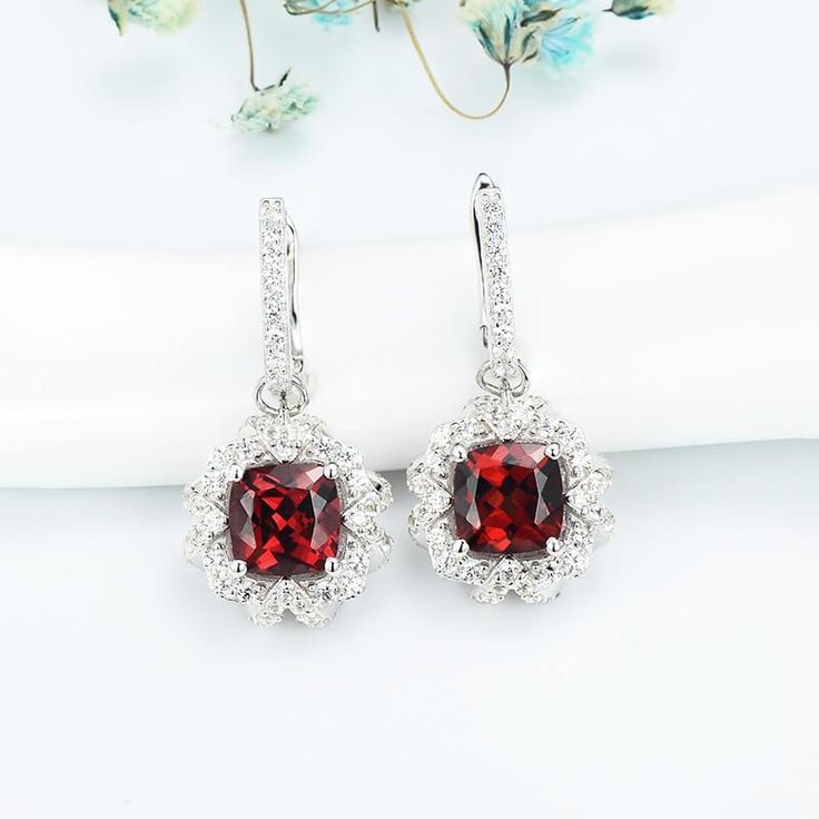 Features These Cushion Ruby Halo Sterling Silver Drop Earrings feature a classic and stylish design style suitable for any occasion.Made all by hand! It truly deserves a spot in every jewelry collection. Beautifully crafted, this style is sure to become a treasured keepsake. Each Ruby used for our jewelry was carefully checked and verified by our experts, so that they meet the highest standard. Providing high-quality items is our most important goal, which starts with selecting the best stones a Fine Jewelry Halo Design Drop Earrings, Elegant Red Hoop Earrings For Formal Occasions, Sterling Silver Halo Drop Earrings, Classic Halo Drop Earrings, Elegant Red Sterling Silver Hoop Earrings, Halo Dangle Earrings For Anniversary, Classic Red Halo Design Earrings, Red Halo Design Earrings For Wedding, Elegant Halo Drop Earrings Jewelry