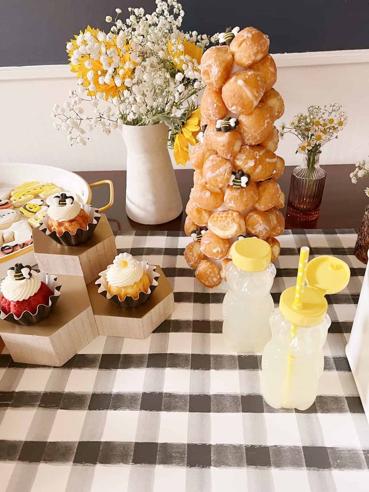 a table topped with donuts and cupcakes on top of eachother