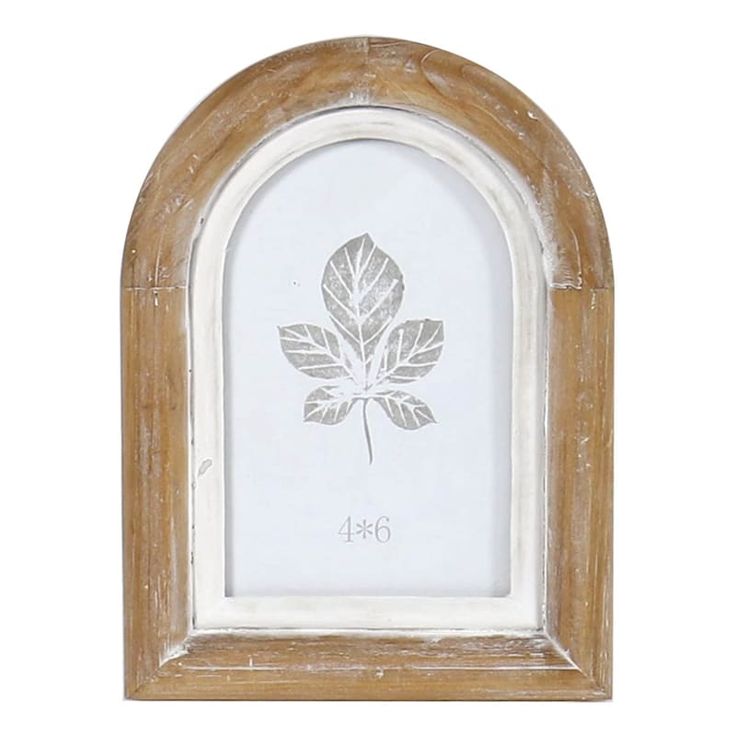 a white and wooden frame with a leaf etched in the center, on a white background