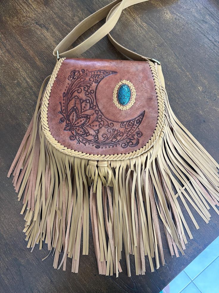 Leather   Hand tooled  Handbag  Adjustable strap  Fully lined with an inside pocket Bohemian Hand Tooled Saddle Bag, Leather Satchel Saddle Bag For Festivals, Hand Tooled Festival Satchel Bag, Bohemian Hand-tooled Bags For Everyday Use, Leather Crossbody Shoulder Bag For Festivals, Leather Hobo Bag Crossbody For Festival, Bohemian Hand Tooled Satchel For Travel, Leather Crossbody Hobo Bag For Festivals, Bohemian Brown Bags With Leather Backing