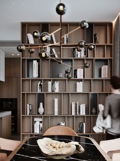 a dining room table and chairs with bookshelves in the backgroung