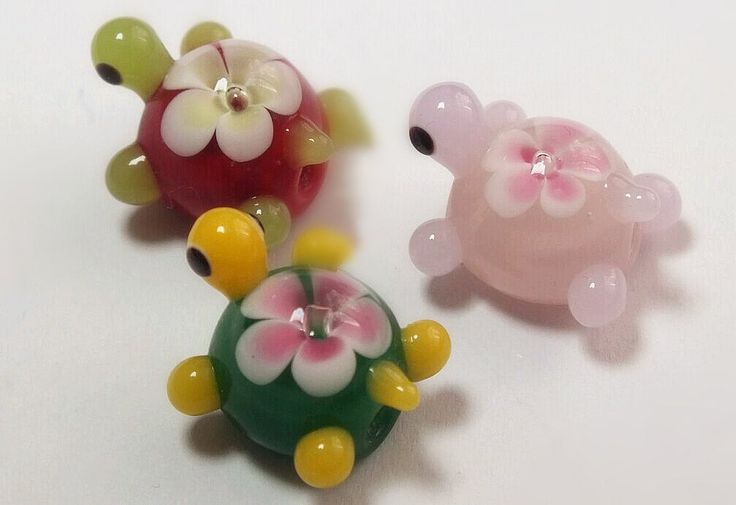 three glass turtle figurines sitting next to each other on a white table top