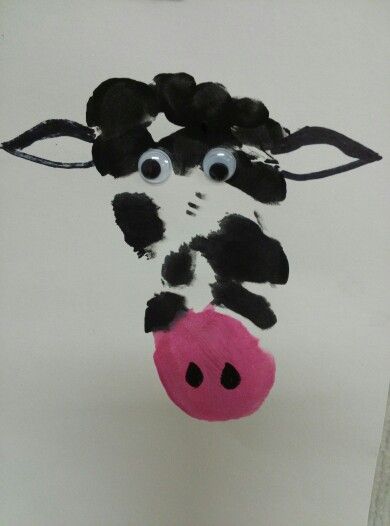 a paper plate with a cow painted on it's face and eyes hanging from the ceiling