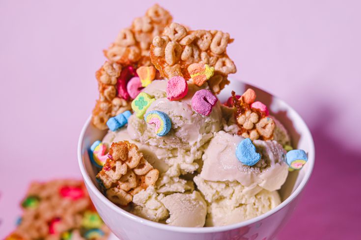 a bowl filled with ice cream covered in cereal krispy kreme candy bars