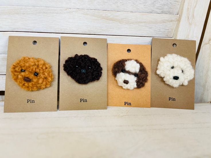 four small crocheted dogs are on brown tags with white and black dog's faces