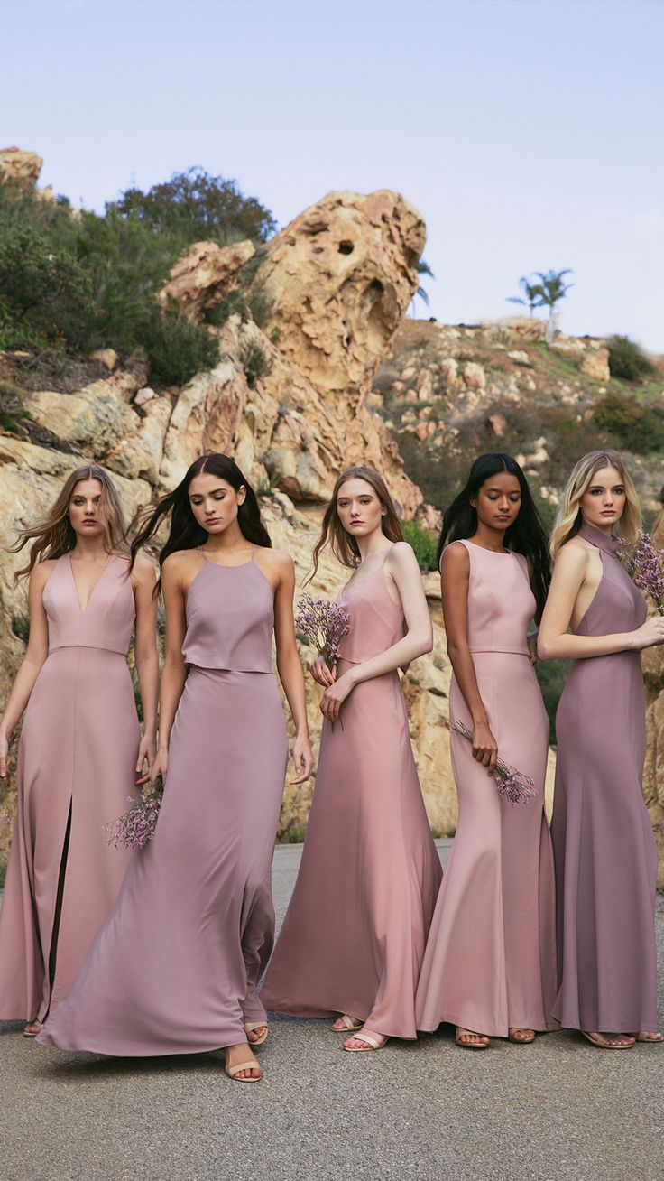 bridesmaids in dusty pink dresses posing for the camera