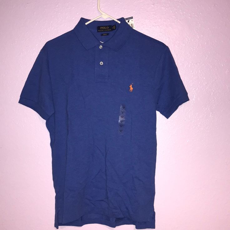 Two Button. Slim Fit. Orange Logo. Pretty Blue. Fitted Polo Shirt With Buttons For Spring, Spring Fitted Button-up Polo Shirt, Blue Collared Polo Shirt With Button Closure, Blue Polo Collar Top With Buttons, Solid Spring Polo Shirt With Button Closure, Solid Polo Shirt With Button Closure For Spring, Light Blue Fitted Polo Shirt With Polo Collar, Fitted Light Blue Polo Shirt With Polo Collar, Fitted Blue Button-up Polo Shirt