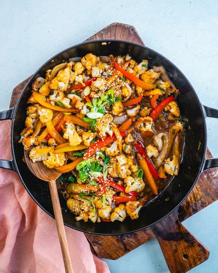 a skillet filled with cauliflower, carrots and other veggies