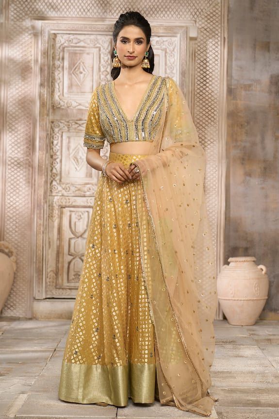 Ochre lehenga with floral pattern woven motifs. Comes with mirror embroidered blouse and butti embroidered dupatta. - Aza Fashions Dola Silk Palazzo Set With Zari Work For Reception, Gold Dola Silk Sets With Mirror Work, Festive Sharara With Mirror Work, Unstitched Raw Silk Lehenga With Gota Work, Unstitched Palazzo Set With Mirror Work For Reception, Festive Chanderi Lehenga With Resham Embroidery, Unstitched Festive Lehenga With Resham Embroidery, Unstitched Lehenga With Resham Embroidery For Festive Occasions, Unstitched Festive Resham Embroidered Lehenga