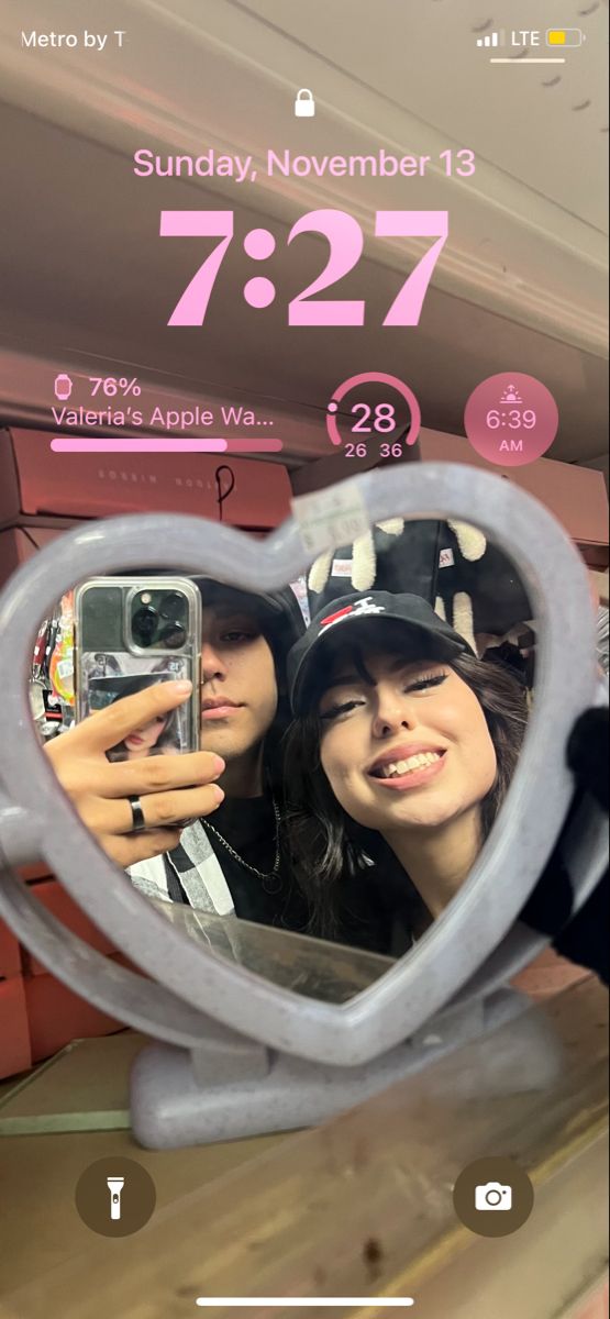 two people taking a selfie in a heart shaped mirror with the caption 7 27