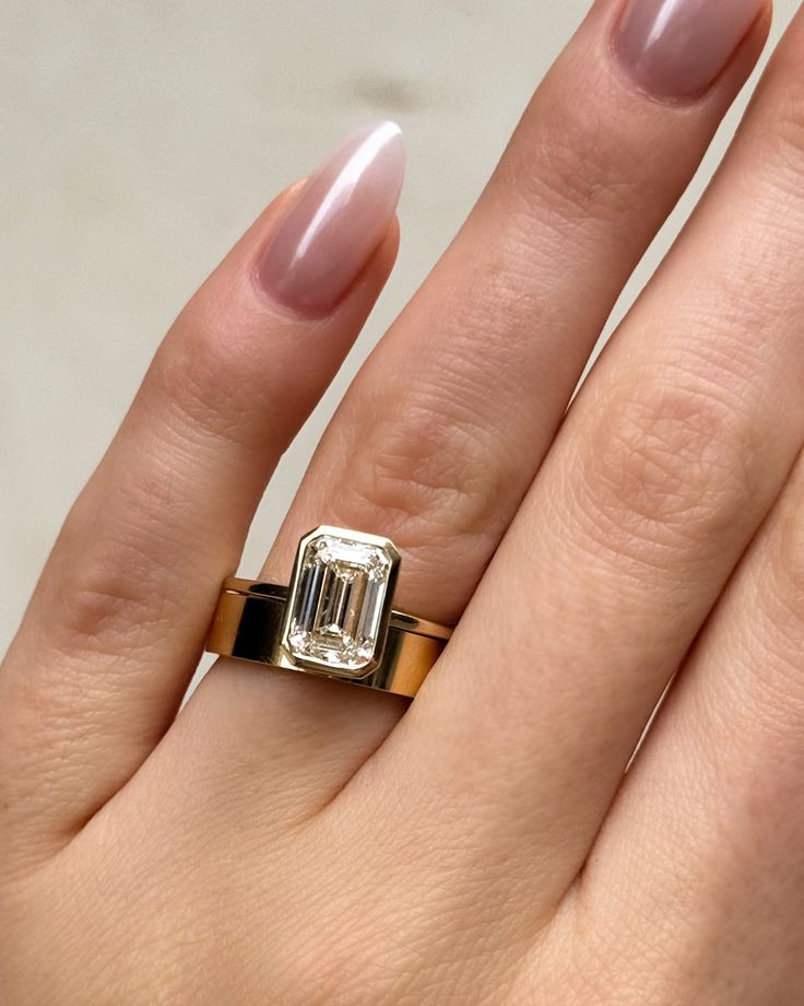 a woman's hand with a ring on it and a diamond in the middle