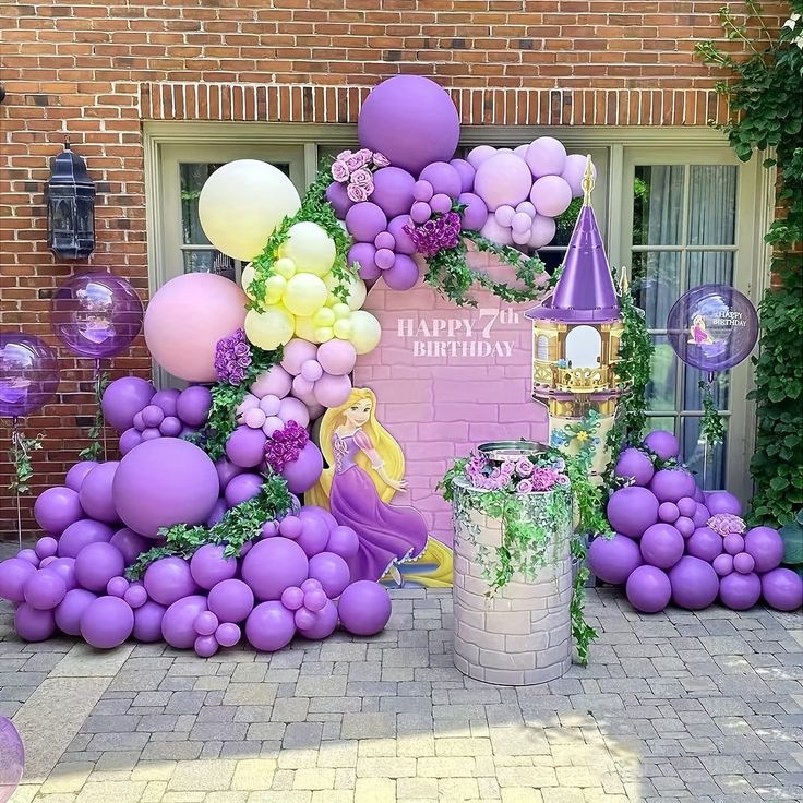 purple and yellow balloons are on display in front of a brick building