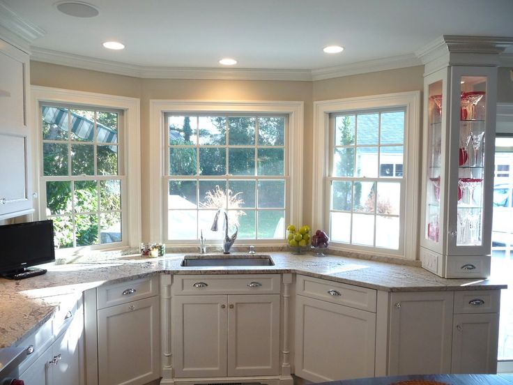 a large kitchen with white cabinets and marble counter tops, along with an island in the middle