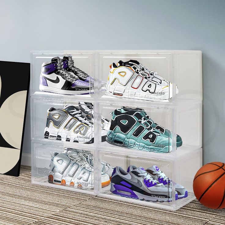 four clear acrylic boxes with different types of shoes in them next to a basketball