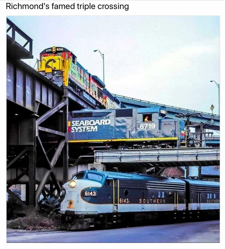 a train traveling down tracks under a bridge