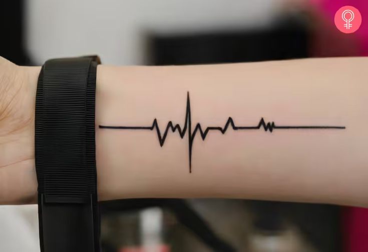 a woman's arm with a heartbeat tattoo on it