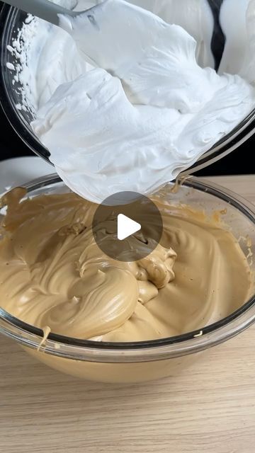 a bowl filled with cream sitting on top of a wooden table