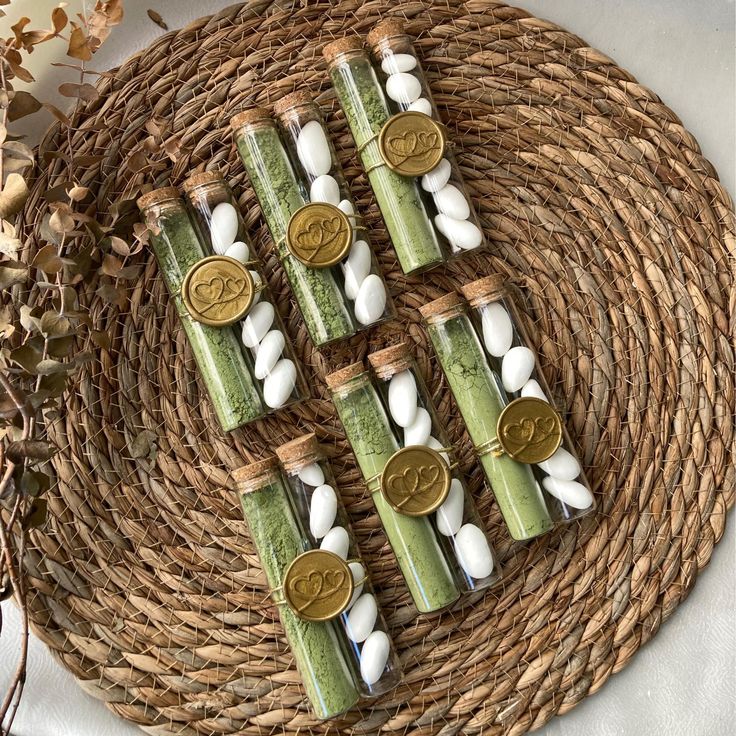 four green and white candles sitting on top of a wicker basket